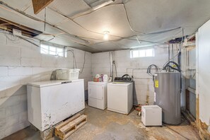 A laundry room with a washing machine, dryer, and stacked wooden pallets.