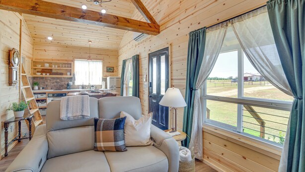 A cozy cabin interior with a sofa, a lamp, and a view of the outside. - Pond & Grazing Cattle! Rural Getaway Near Van (Van)