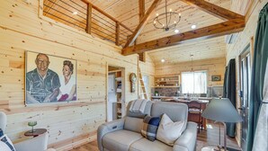 A cozy cabin interior with a sofa, a dining area, and a kitchen. - Pond & Grazing Cattle! Rural Getaway Near Van (Van)