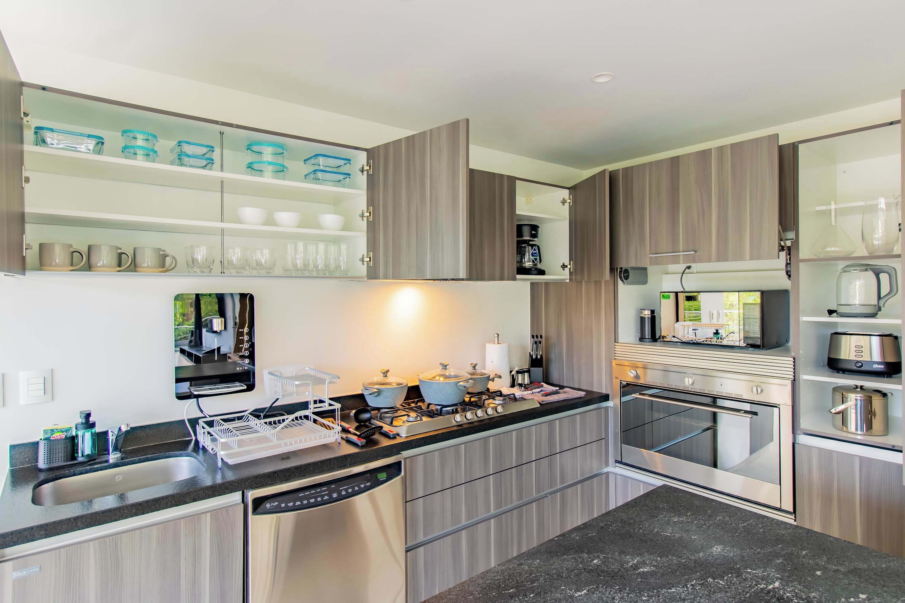 Een koelkast met diepvriezer, een microgolfoven, een oven, een kookplaat