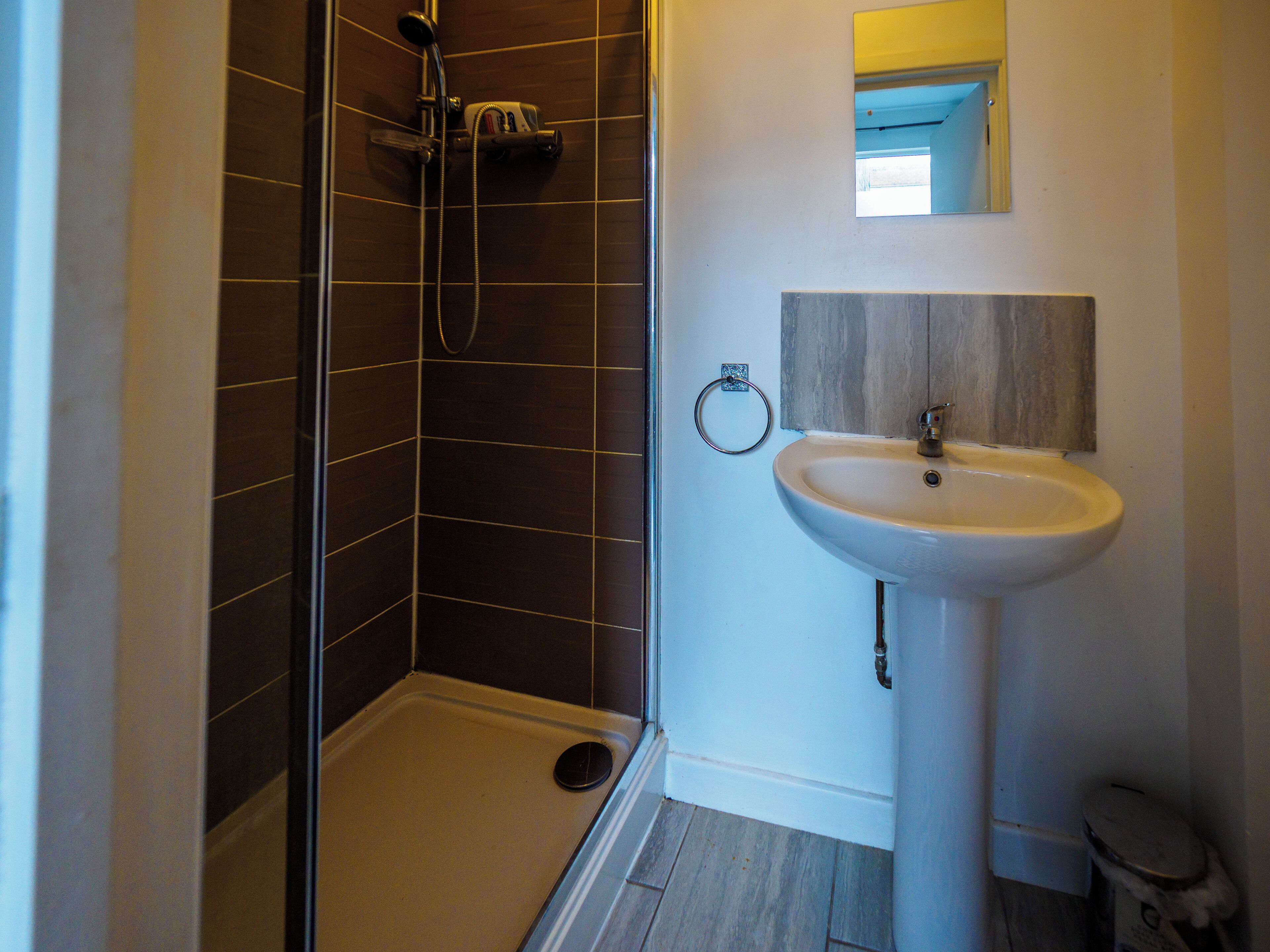 A bathroom with a shower, sink, and toilet.