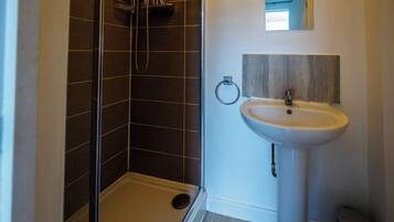 A bathroom with a shower, sink, and toilet.