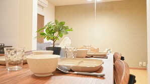 A dining table set with bowls, plates, and a potted plant. - Experience life in a private old private house in the heart of Tokyo｜3 bedrooms, 5 beds｜Excellent access to Akasaka, Roppongi, Ginza, Aoyama, Harajuku, Imperial Palace｜with private workspace (港区)