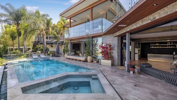 Una piscina al aire libre, sillones reclinables de piscina