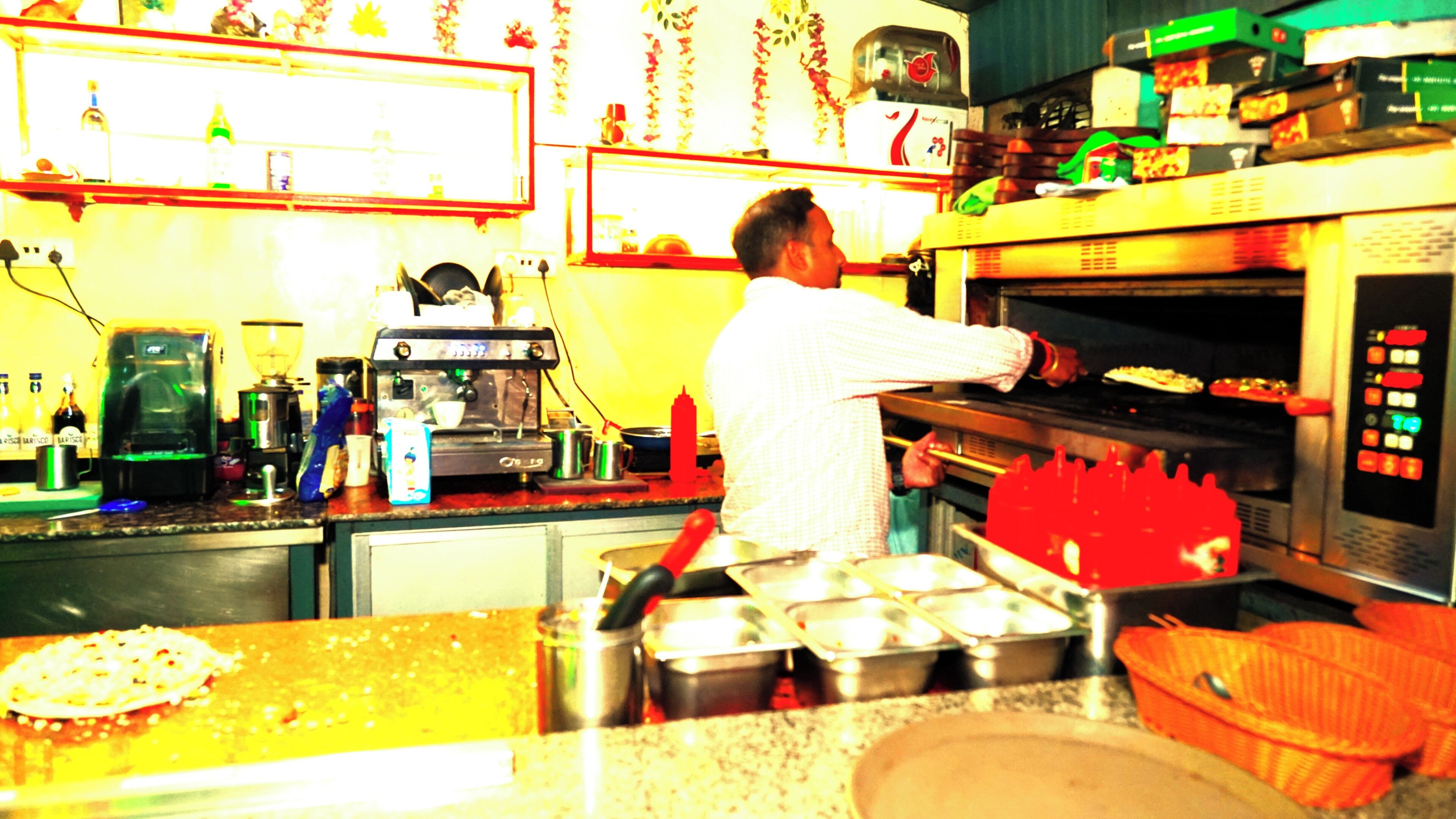 A kitchen with a coffee machine, oven, and various cooking utensils.
