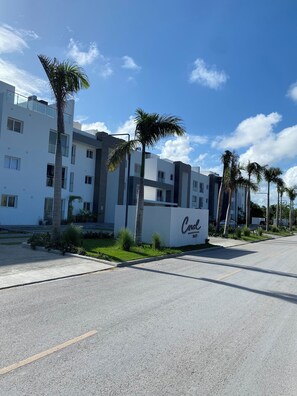 Un bâtiment moderne avec une enseigne indiquant « Craw » et des palmiers devant.