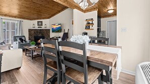 Un rincón comedor acogedor con una mesa de madera, sillas y una chimenea.