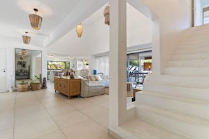 Un área de estar amplia con una escalera, un mueble de madera y un sofá.