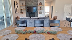 A modern living room with a stone fireplace, a flat-screen TV, and a cozy seating area. - Beautiful 3-bedroom cabin in welcoming Pinetop Country Club (Pinetop Country Club)