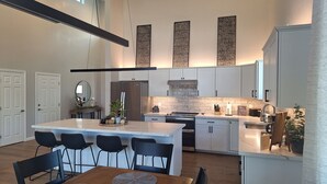 A modern kitchen with a central island, white cabinetry, and a hanging light fixture. - Beautiful 3-bedroom cabin in welcoming Pinetop Country Club (Pinetop Country Club)