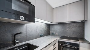 Une cuisine moderne équipée d’un four à micro-ondes Bosch, d’un four encastré et d’un lave-vaisselle.