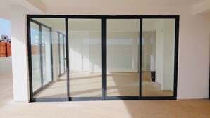 Amplia habitación con un gran ventanal corredero que da a un espacio exterior.
