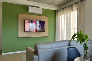 Appartement | Woonruimte | Een 50-inch flatscreentelevisie met satellietzenders