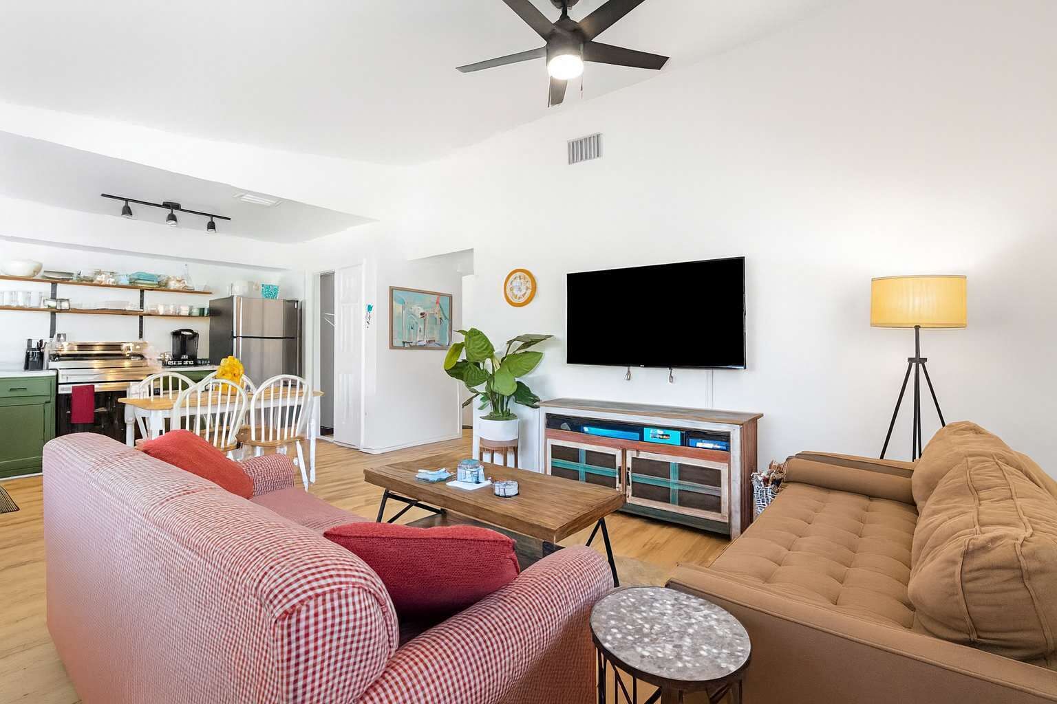 A modern living room with a sofa, a coffee table, and a TV mounted on the wall.
