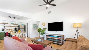 Un salon moderne avec un canapé, une table basse et un téléviseur fixé au mur.