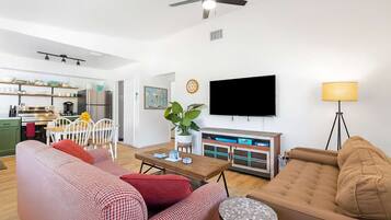 A modern living room with a sofa, a coffee table, and a TV mounted on the wall.