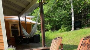 A wooden deck with two Adirondack chairs, a hammock, and a potted plant with lavender. - Cozy 3 bd, 8 min North Side Tremblant ski lifts (Lac-Supérieur)