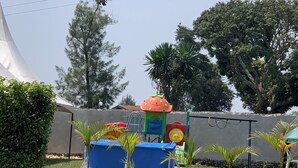 A garden area with potted plants and a play structure. - Peaceful, quiet 4-bedroom holiday home @Karambi, Fort Portal Tourism City Uganda (Fort Portal Tourism City)