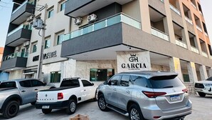 A multi-story hotel with balconies, parked cars, and construction cones. - Garcia Palace Hotel (Marabá)