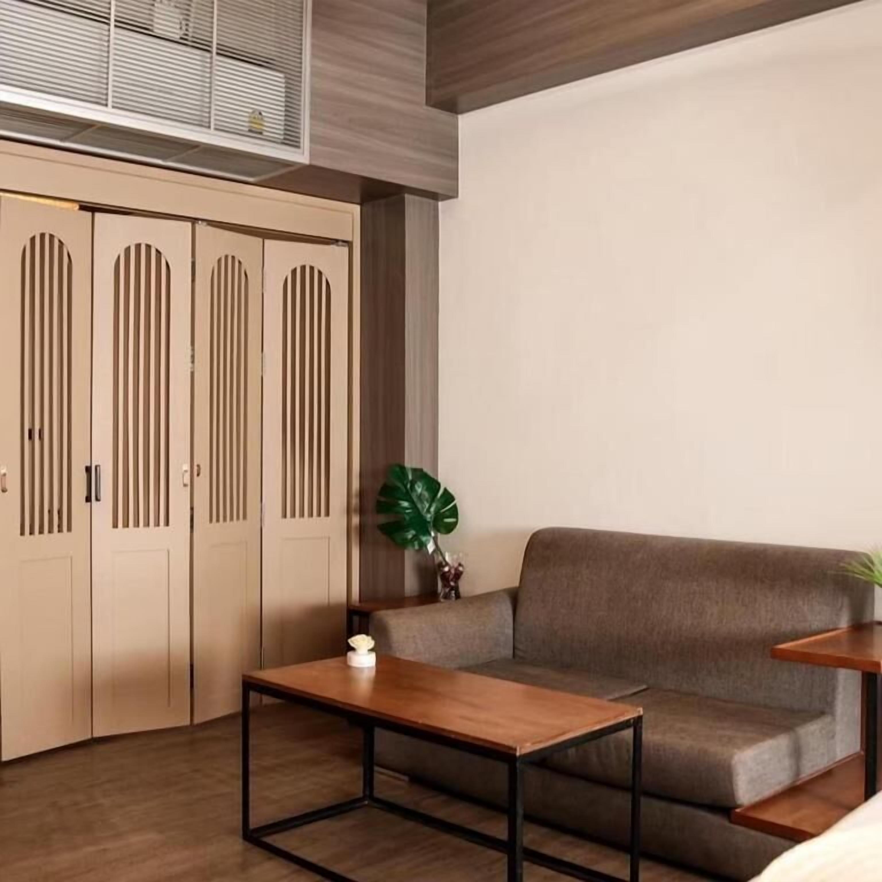 A modern room with a sofa, a wooden table, and a plant.