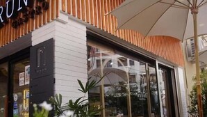 Un restaurant à la façade rayée, doté d’une terrasse.