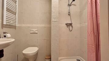 Een douche, handdoeken, toiletpapier