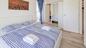 A hotel room with a large bed, a bathroom, and a view of a field.