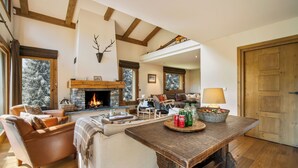 A cozy living room with a fireplace, leather sofas, wooden beams, and a stone fireplace surround. - 7BR Luxury Chalet with Hammam, Cinema, gym and Mont Blanc Views in Megeve Alps (Megève)