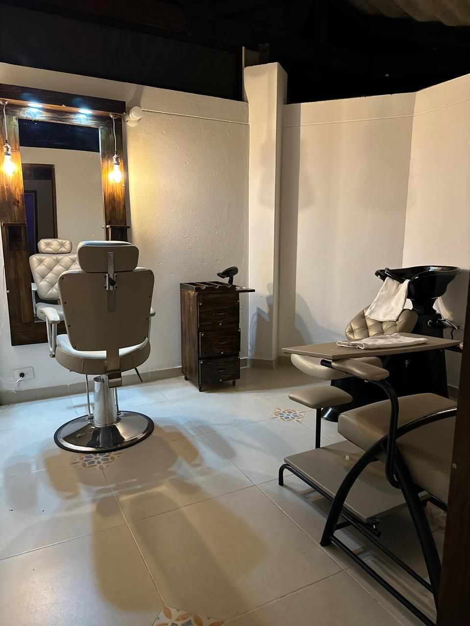 A salon with two barber chairs, a mirror, and a sink.