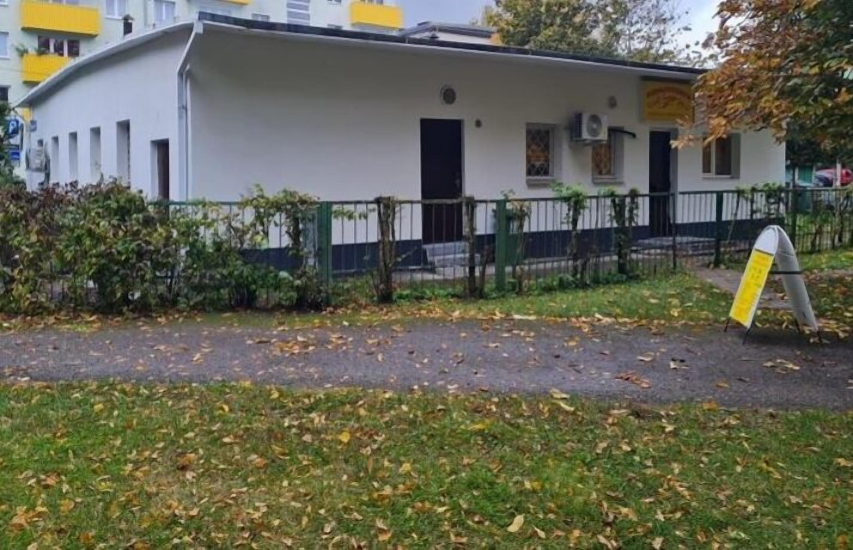 A white building with a curved roof, a black door, and a small window.