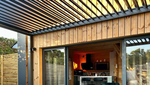 A modern outdoor kitchen area with a built-in grill, bar stools, and a hot tub. - Cosy escape in a small chalet 🏠 with outdoor jacuzzi! (Eslettes)
