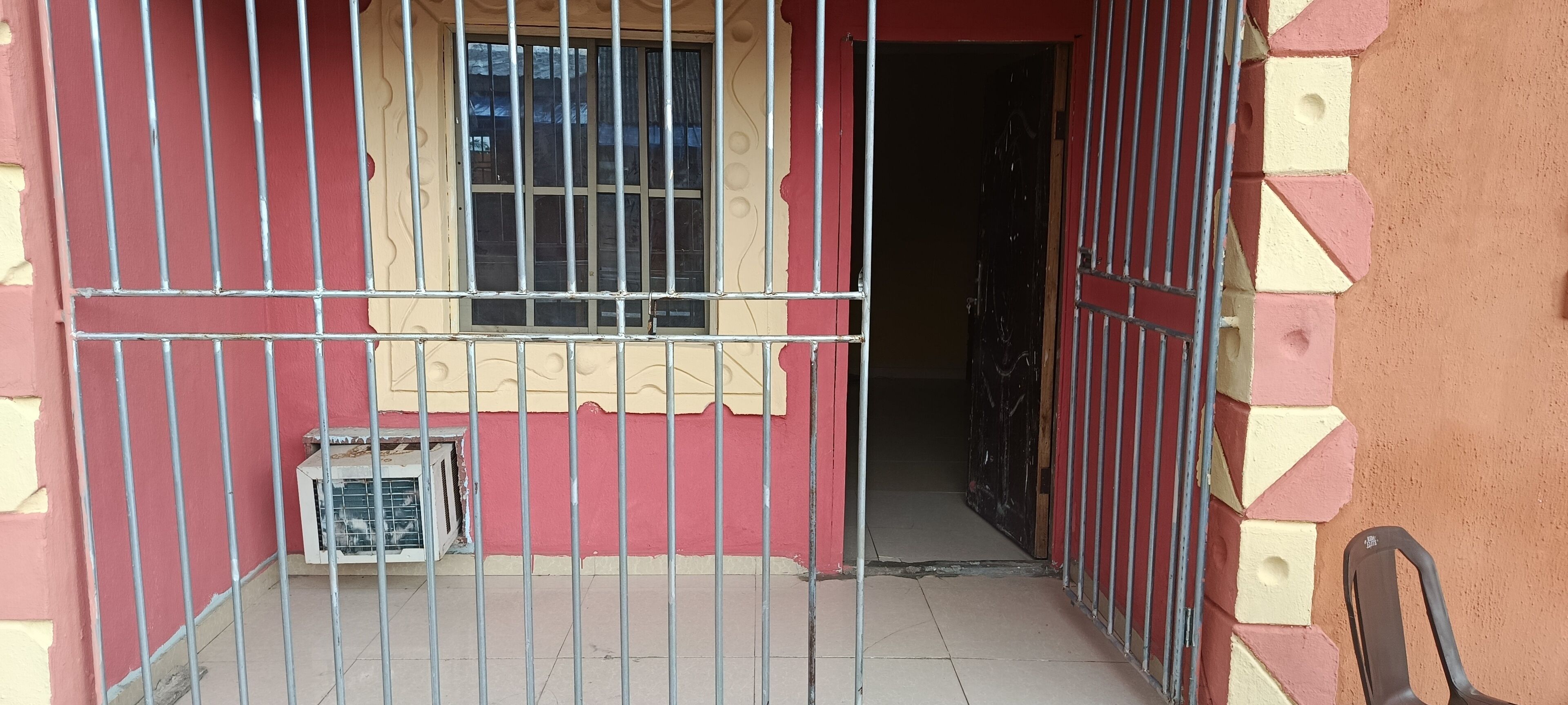 Una entrada protegida con una ventana y una pequeña mesa.