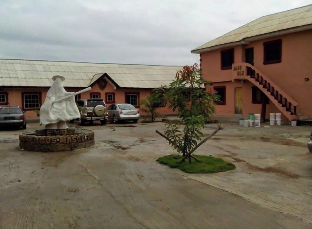 A building with a pink facade, a staircase, and a statue in the foreground.