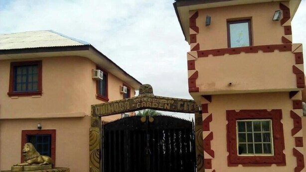 Un edificio con una reja negra, una estatua de león y un cartel que dice 'Welcome to the City'.