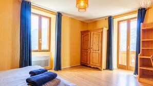 Ein Schlafzimmer mit Bett, Kleiderschrank und Blick durch ein Fenster.