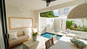 Un interior moderno con piscina, sofá, mesa y ventilador de techo.
