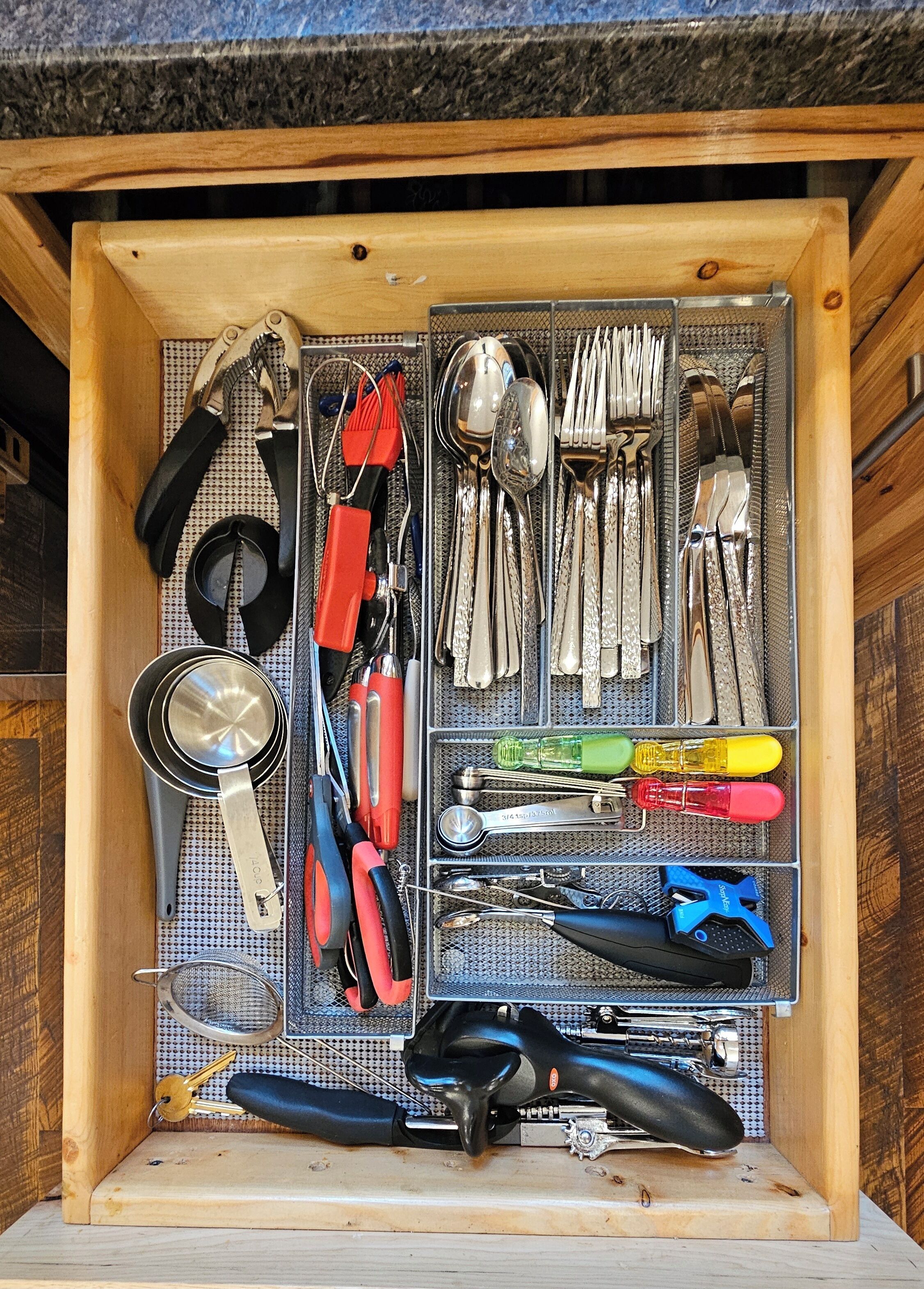Un panneau perforé servant d’organisateur, avec des outils et des ustensiles.