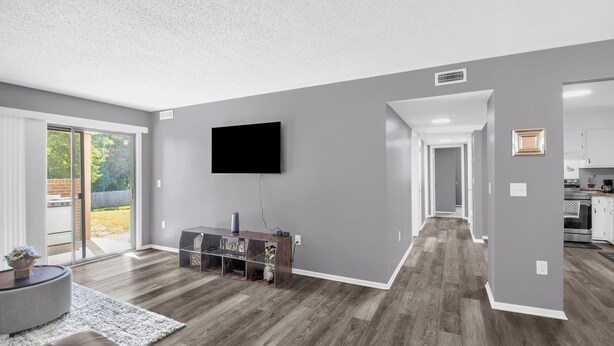 A modern living room with a flat-screen TV, a wooden entertainment unit, and a grey sofa. - 3BR 2bath Apt. Near Downtown High Point and High point University sleeps  6 (High Point)
