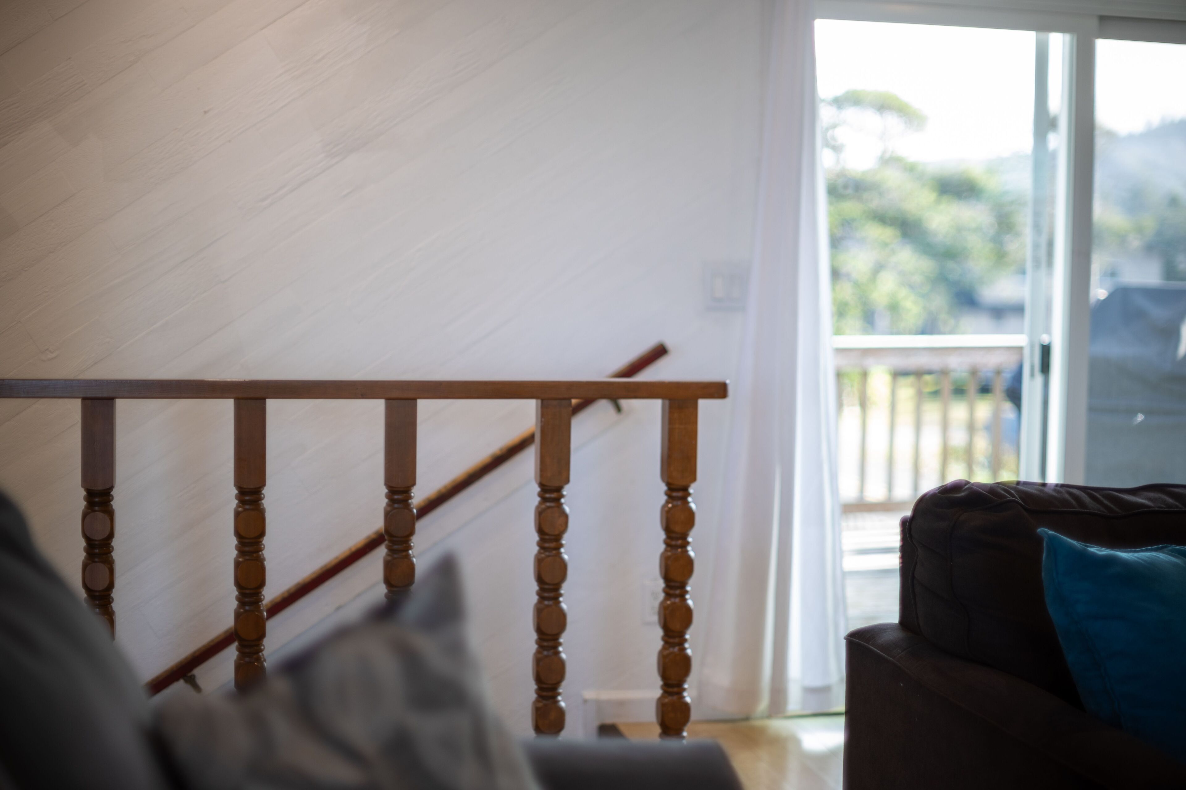 Een houten trap met een leuning die uitkomt op een balkon.