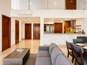 A modern apartment with a living room, dining area, and kitchen.