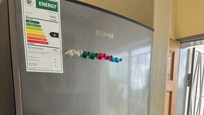 A stainless steel refrigerator with a water dispenser and a sticker indicating energy efficiency.