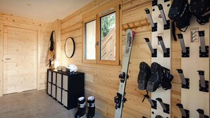 Espaço para guardar esquis com esquis, botas de esqui e um capacete.