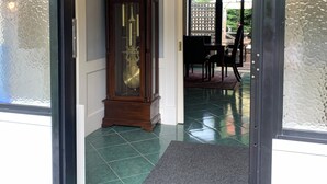 A spacious foyer with a large grandfather clock, a chandelier, and a view into a dining area. - Trentham Akyra Lodge - 3 bedrooms- Walk to town.  (Trentham)