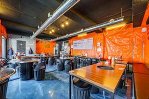 A restaurant with tables and chairs, a menu board, and a blue floor. - Staylibera (Gangneung)