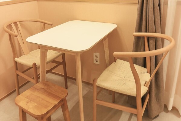 A small room with a white table and two wooden chairs with woven seats. - Staylibera (Gangneung)