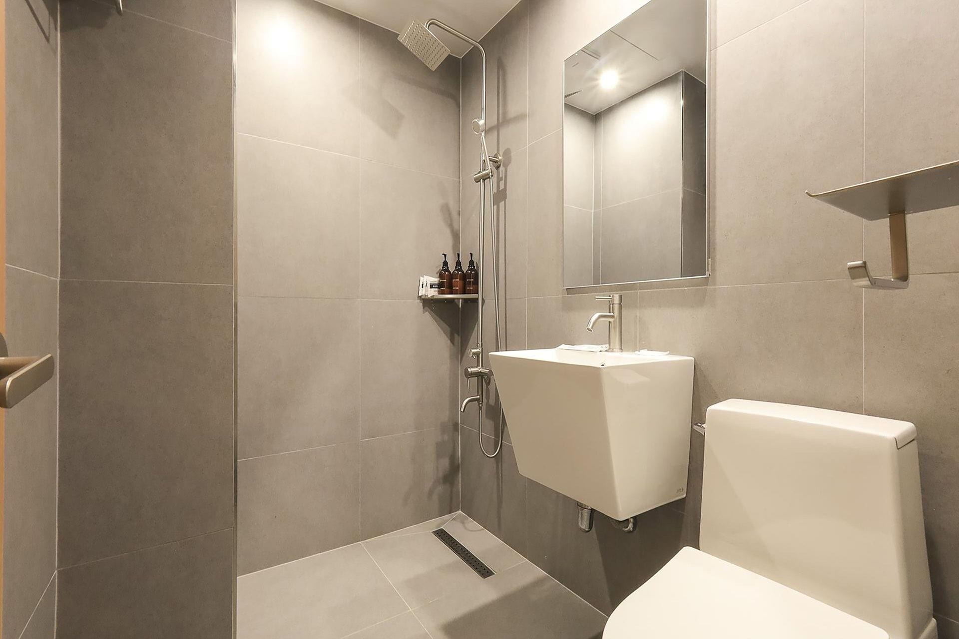 Familiekamer | Badkamer | Een douche, een haardroger, handdoeken