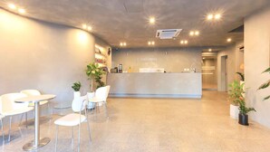 A reception area with a counter, chairs, and potted plants. - Staylibera (Gangneung)