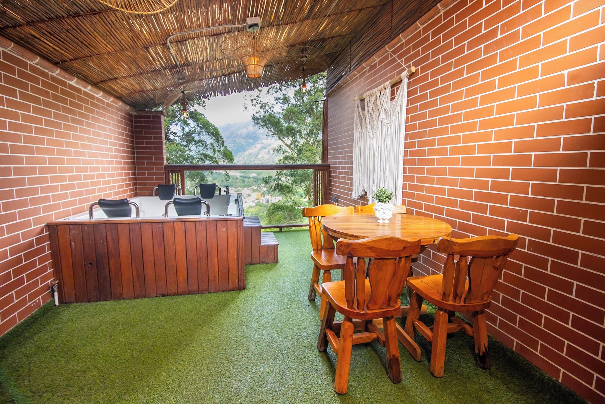 Un patio con mesa y sillas de madera, un jacuzzi y vistas a la montaña.