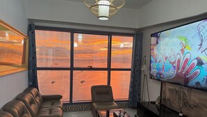 A living room with a large window, a sofa, a coffee table, and a TV. - KanStay Sea View Condo by Manila Bay｜康宿·海境居 (Manila)