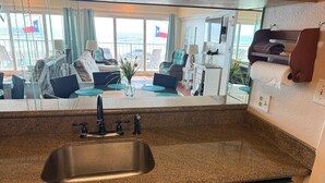 A kitchen with granite countertops, a stainless steel sink, and a Samsung dishwasher. - Relaxing Beachfront Oceanview Condo w/2 Beds 2 Full Baths, Kitchen, Pet Friendly (Galveston)